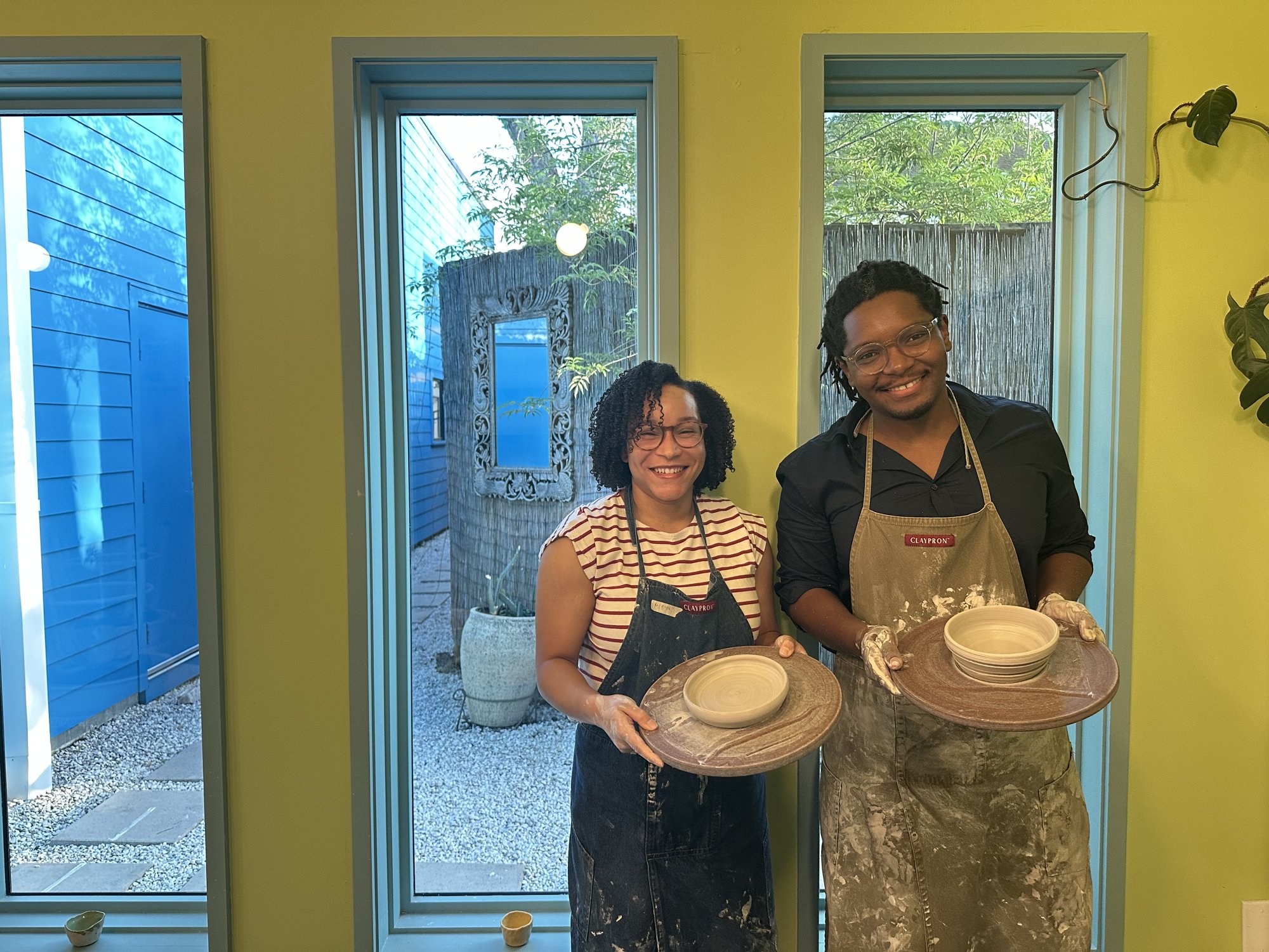 Magen and Thomas showing their pottery